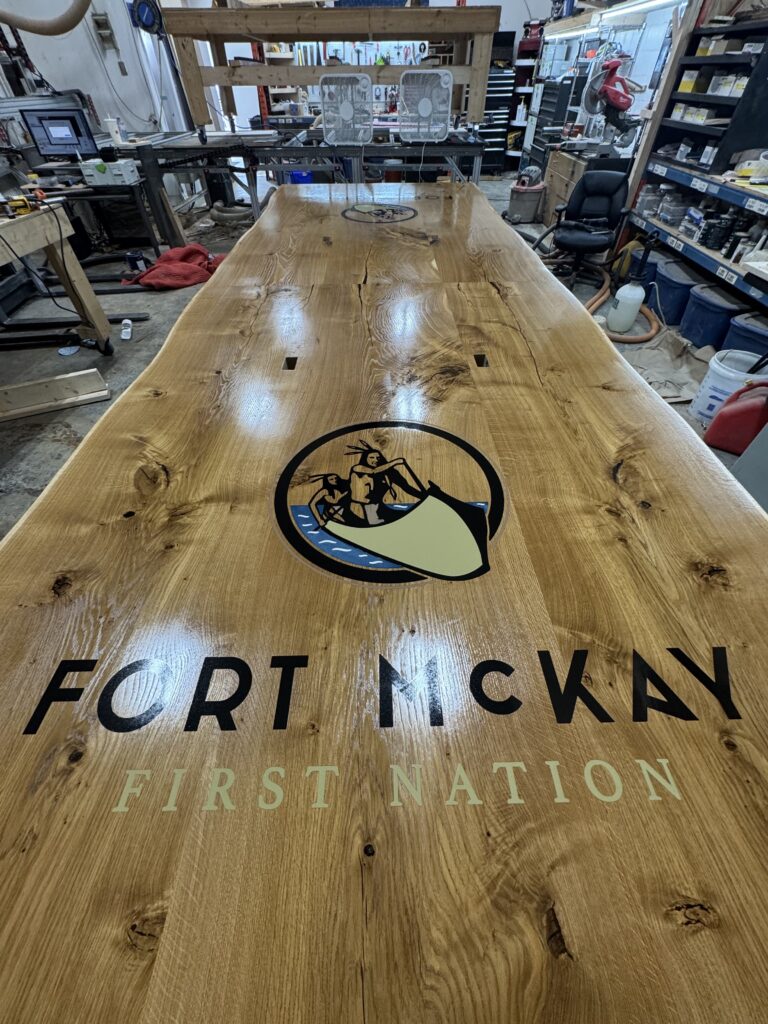 Massive white oak conference table featuring two 4x4 epoxy logos