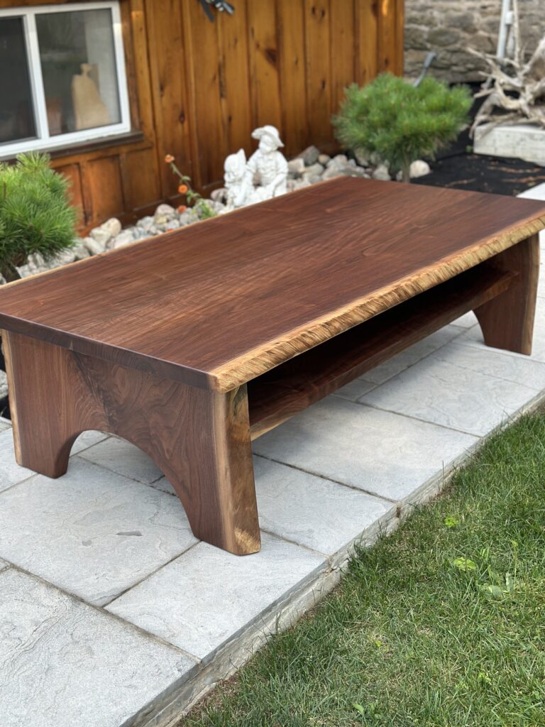 Black walnut coffee table with half-moon wood base and lower shelf