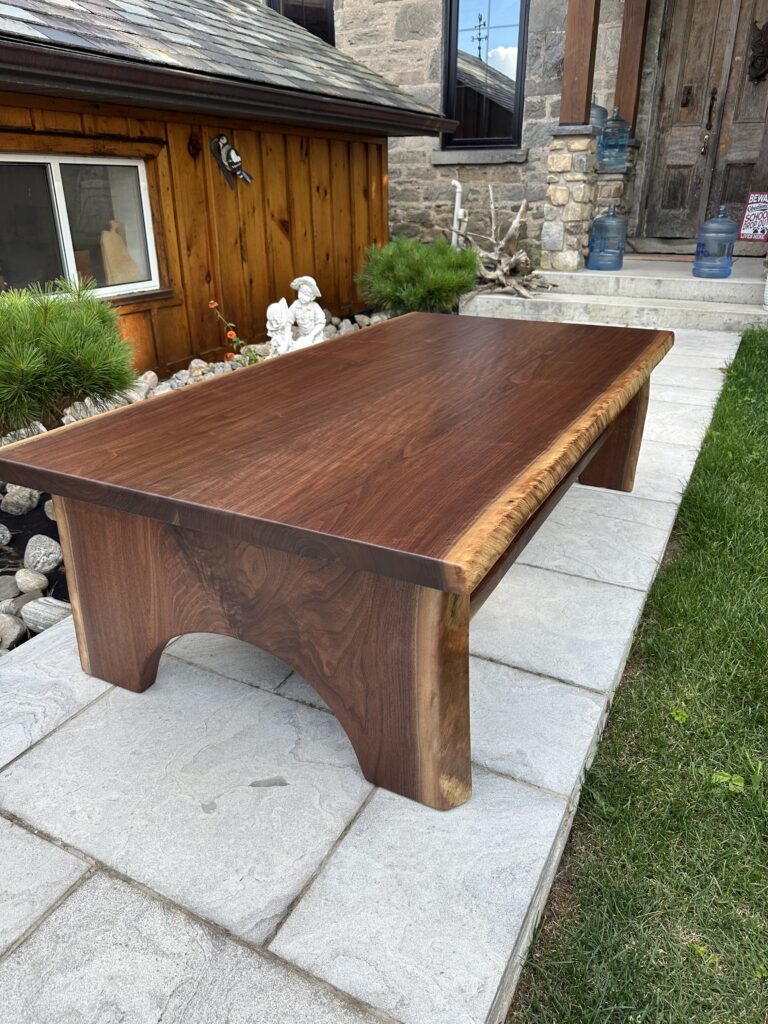 Black walnut coffee table with half-moon wood base and lower shelf