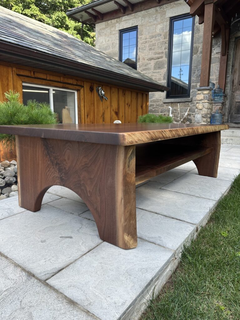 Black walnut coffee table with half-moon wood base and lower shelf