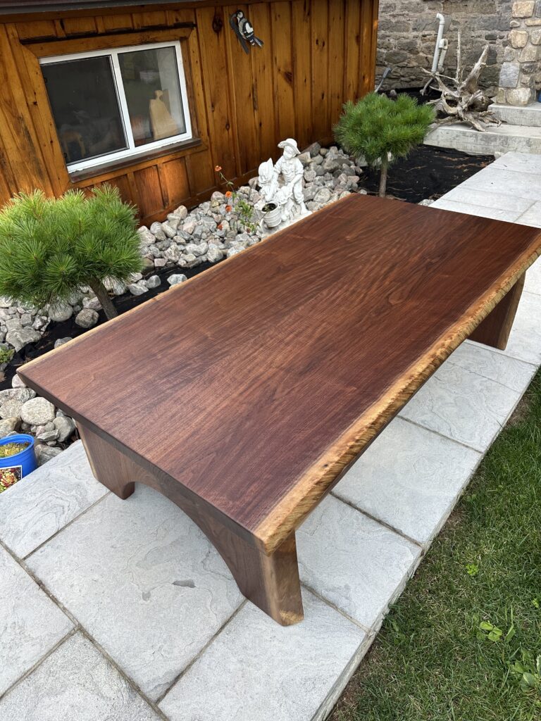 Black walnut coffee table with half-moon wood base and lower shelf