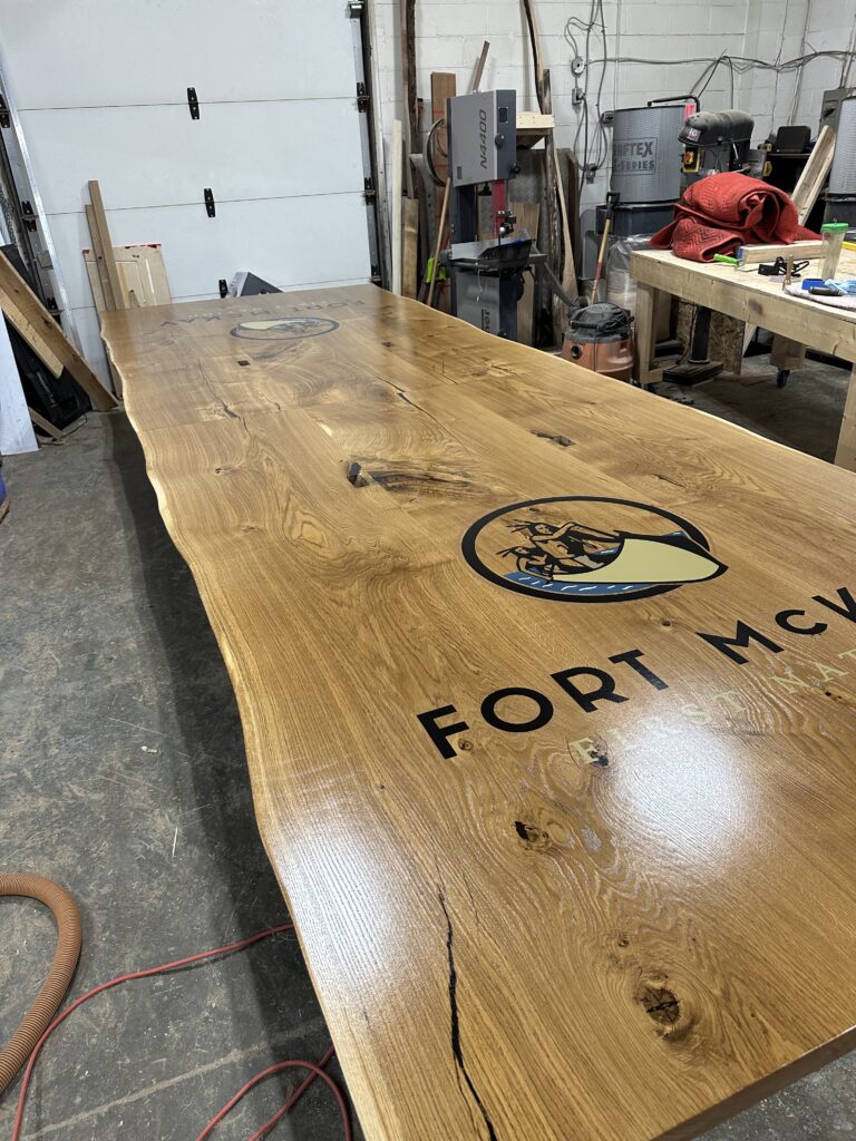 Massive white oak conference table featuring two 4x4 epoxy logos White Oak conference table